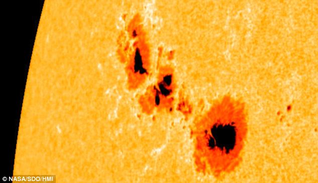 why do sunspots appear darker than the surrounding plasma in the sun